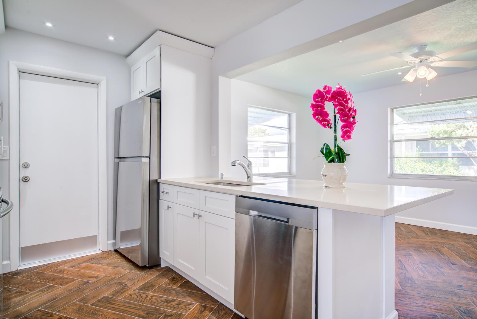 A kitchen with white cabinets, stainless steel appliances, and herringbone-patterned wood flooring — 813 SW 5th Court, Boynton Beach FL 33426, BOYNTON BEACH, FL
