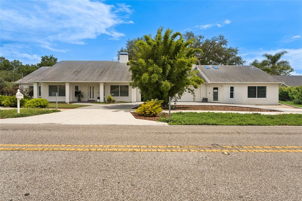 A single-story white house with a gray roof and a large central tree — 4404 SIMMONS ROAD, ORLANDO, FL