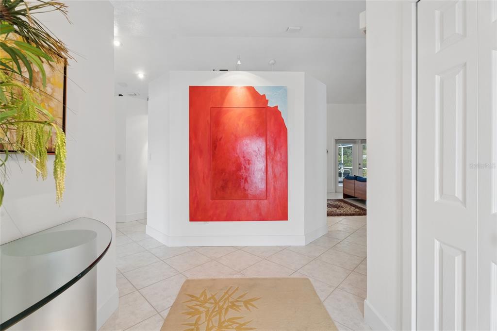 A bright entryway features a large red abstract painting on a central white wall — 4404 SIMMONS ROAD, ORLANDO, FL