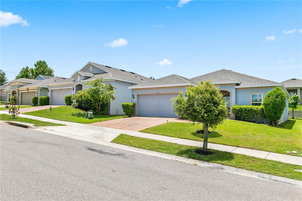 A street view of two single-story suburban houses with attached garages and manicured lawns — 9809 LATE WAY, GROVELAND, FL