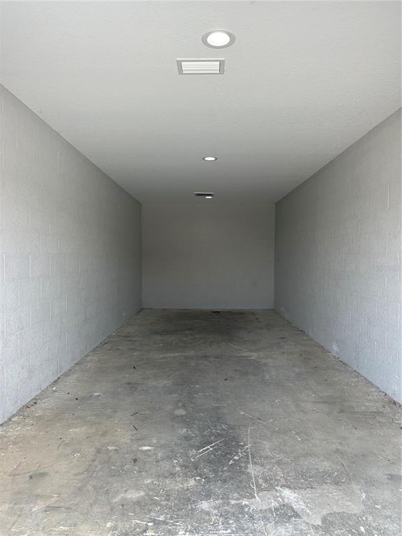 An empty garage with gray concrete block walls, a concrete floor, and recessed ceiling lights — 110 SPIRIT LAKE ROAD UNIT 9, WINTER HAVEN, FL