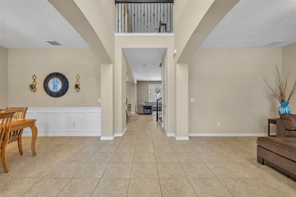 A tiled entryway leads to a living area with a high ceiling and balcony overlook — 14001 RUGBY STREET, OAKLAND, FL