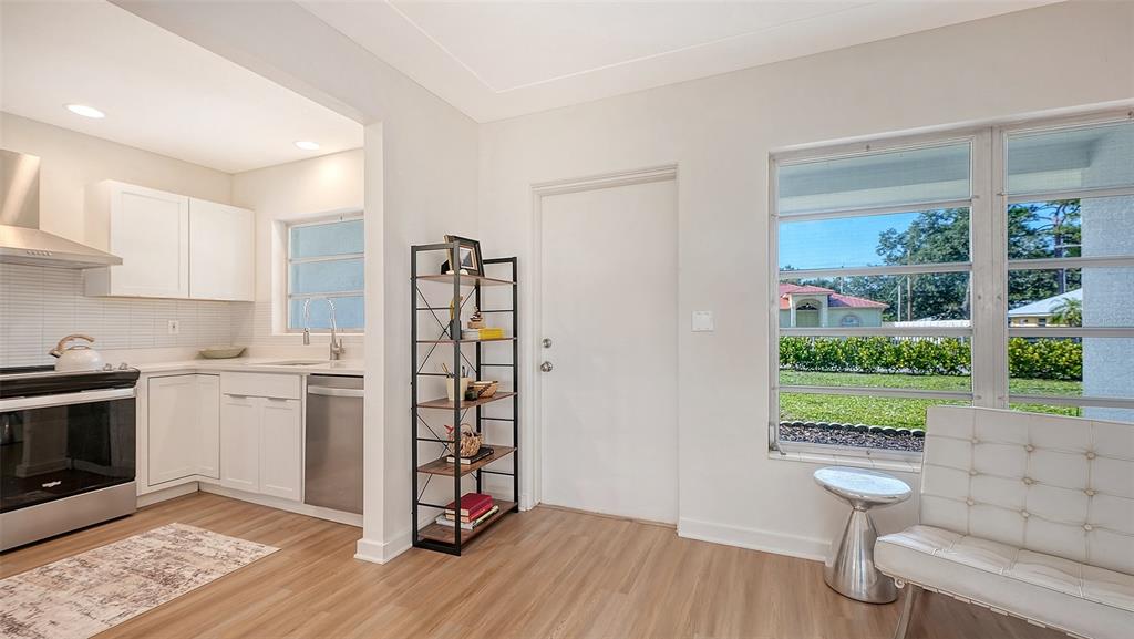 A kitchen with white cabinets and stainless steel appliances opens into a living area — 2719 TEMPLE STREET, SARASOTA, FL