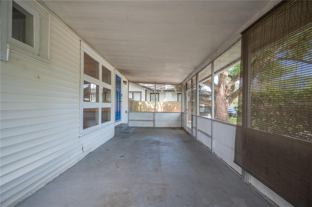 A screened-in porch with a concrete floor and a bright blue front door — 714 W BELMAR STREET, LAKELAND, FL