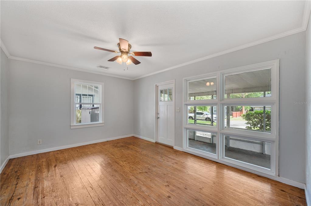 An empty room with hardwood floors, a ceiling fan, a window, and a glass door — 714 W BELMAR STREET, LAKELAND, FL