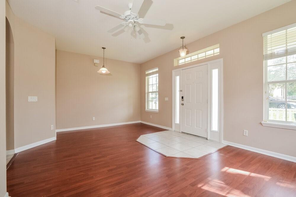 An entryway with a tiled floor leads into a living area with hardwood flooring — 1814 MADISON IVY CIRCLE, APOPKA, FL