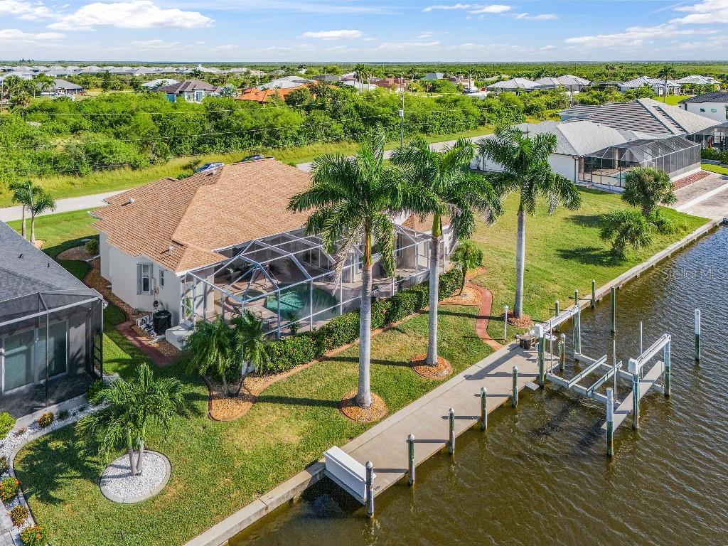 An aerial view of a waterfront house with a screened pool and a private dock — 15626 MEACHAM CIRCLE, PORT CHARLOTTE, FL