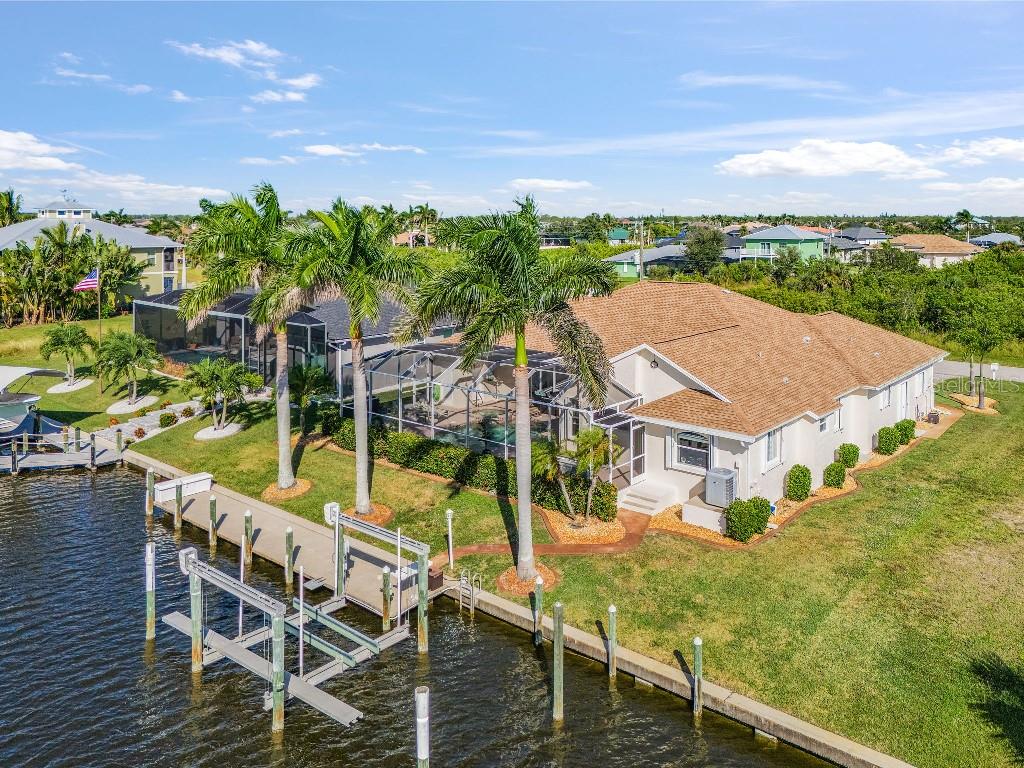 An aerial view of a waterfront house with a screened pool and a private boat dock — 15626 MEACHAM CIRCLE, PORT CHARLOTTE, FL