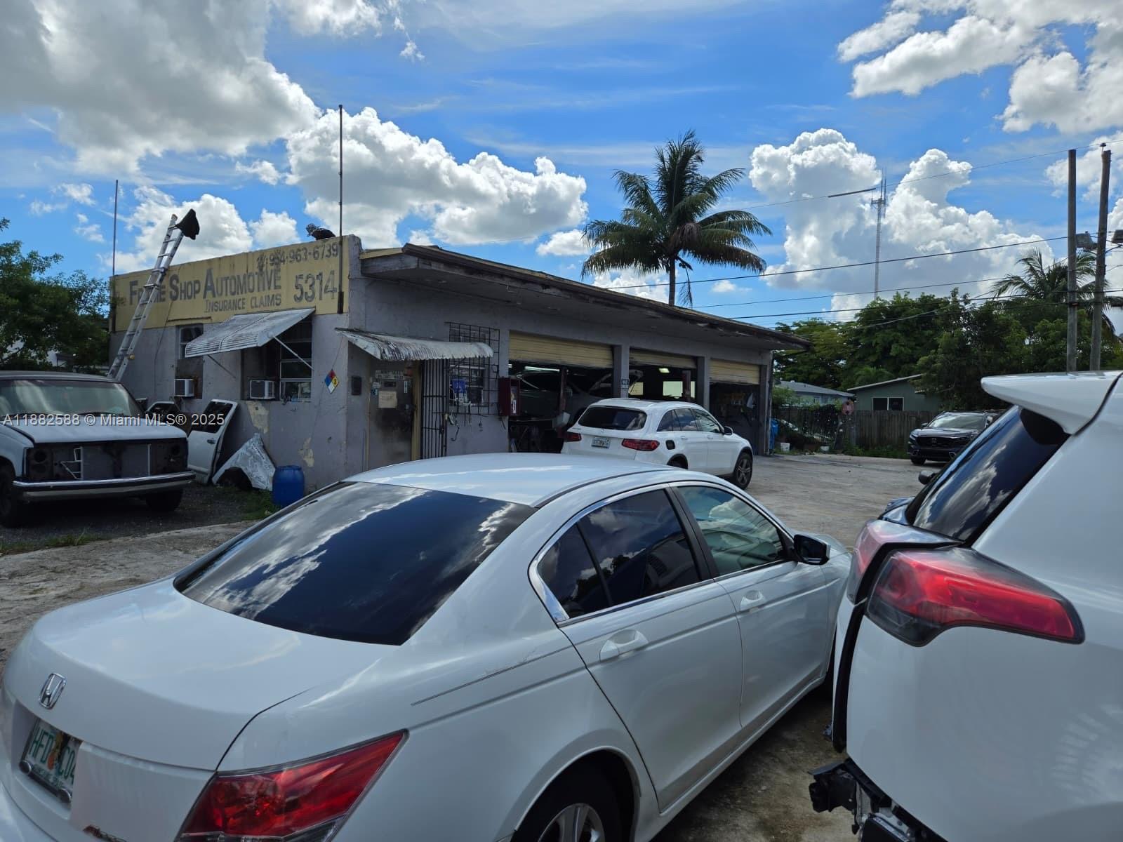 An automotive repair shop exterior features multiple service bays and several parked vehicles — 5314 Pembroke Rd, West Park FL 33021, WEST PARK, FL