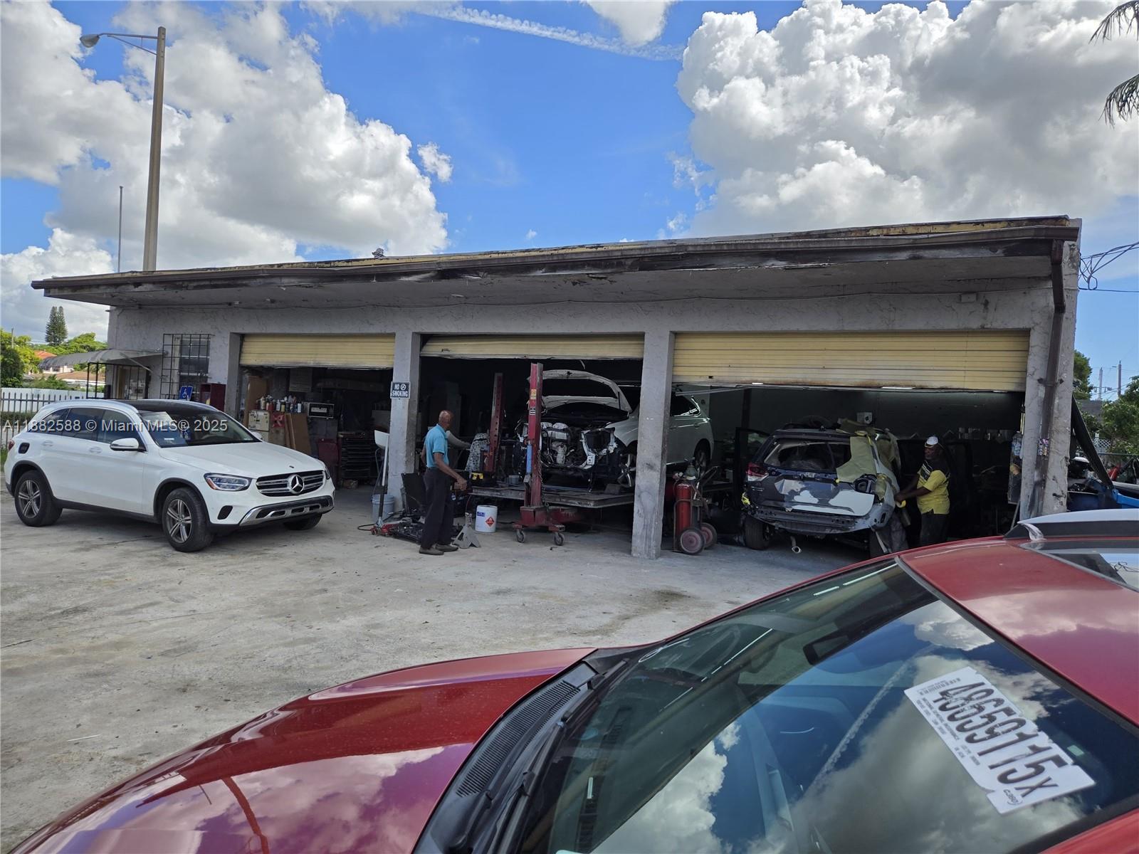 An exterior view of a commercial auto repair shop with three open garage bays — 5314 Pembroke Rd, West Park FL 33021, WEST PARK, FL