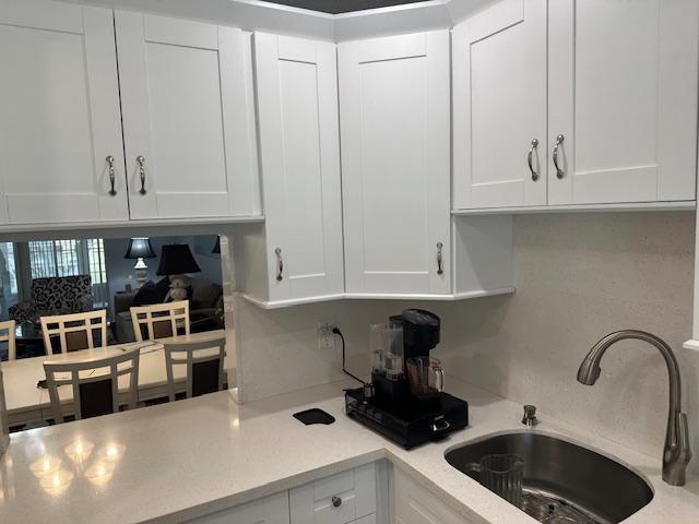 A kitchen features white shaker cabinets, a light-colored countertop, a stainless steel sink, and a coffee maker — 7410 NW 1st Street # 207, Margate FL 33063, MARGATE, FL