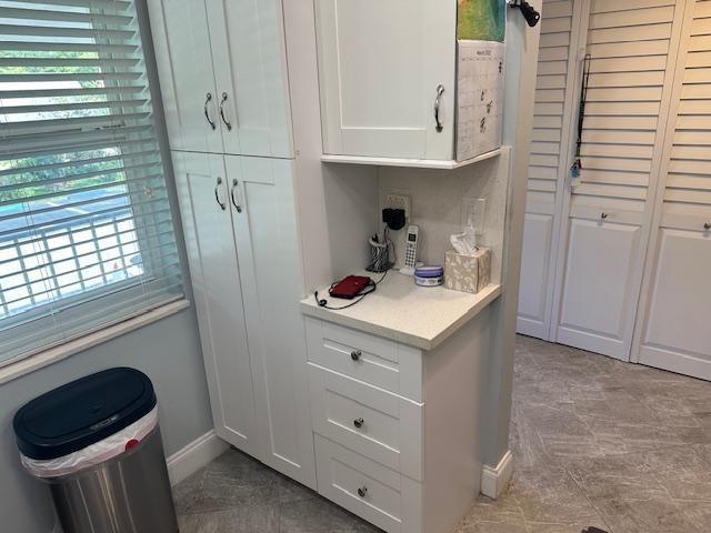 A white built-in cabinet with drawers and a countertop sits next to a window — 7410 NW 1st Street # 207, Margate FL 33063, MARGATE, FL