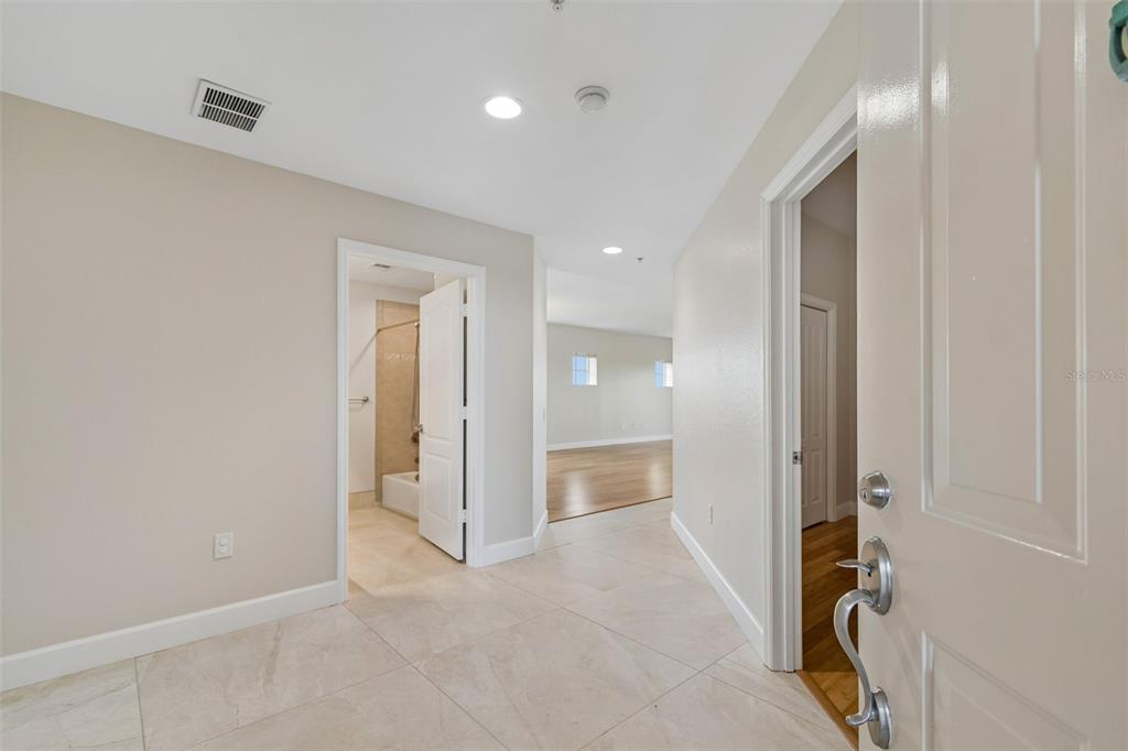 A tiled entryway leads to a bathroom and a room with hardwood flooring — 12033 GANDY BOULEVARD N UNIT 151, ST PETERSBURG, FL