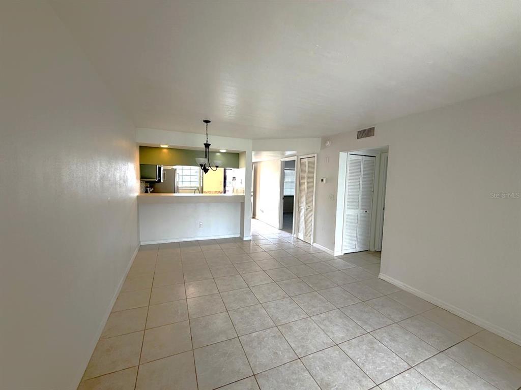 A tiled living area features a breakfast bar opening to a kitchen with pendant lighting — 3128 SIR HAMILTON CIRCLE UNIT 4, TITUSVILLE, FL