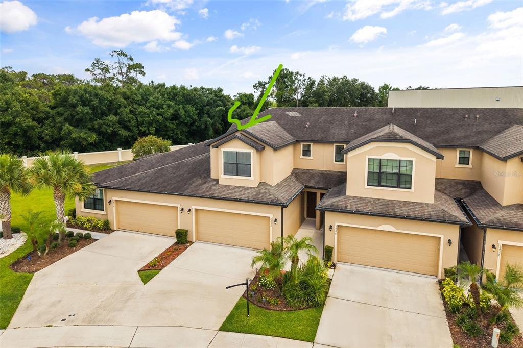 An aerial view of a multi-unit townhouse exterior with a green arrow pointing to a dormer — 2432 SEVEN OAKS DRIVE, ST CLOUD, FL