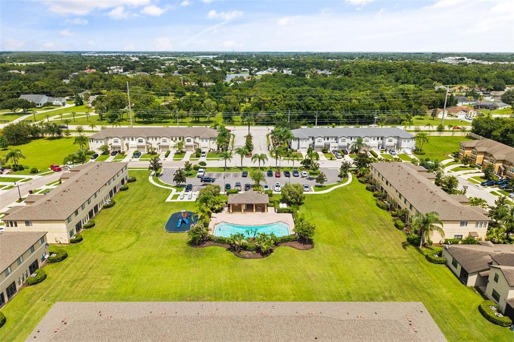An aerial view of a residential complex featuring a swimming pool, playground, and parking lot — 2432 SEVEN OAKS DRIVE, ST CLOUD, FL