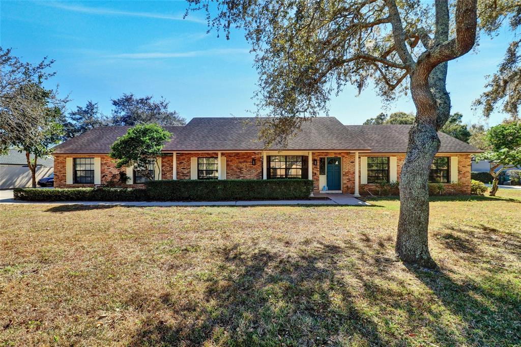 A single-story brick house with a dark shingled roof and a front lawn — 4318 WOODTREE LANE, ORLANDO, FL