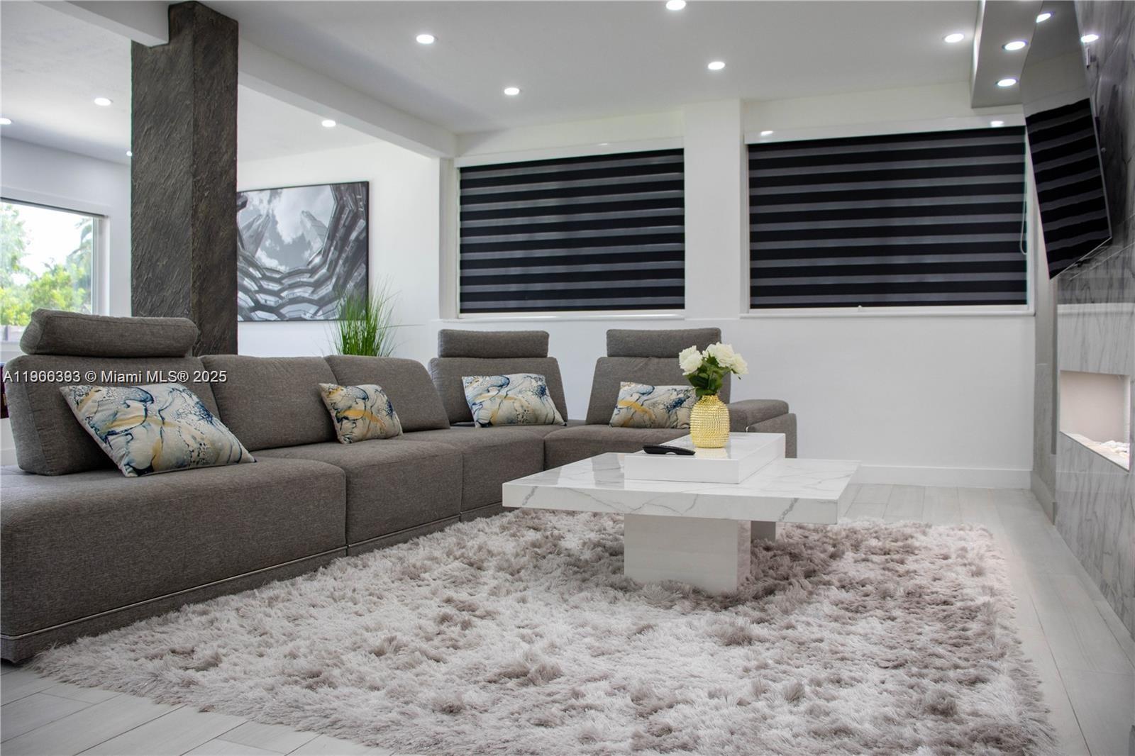 A modern living room features a gray sectional sofa, marble coffee table, and shag rug — 295 NE 150th St, Miami FL 33161, MIAMI, FL