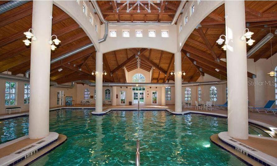 An indoor swimming pool features a high wood-beamed ceiling and large white support columns — 200 OCEAN CREST DRIVE UNIT 231, PALM COAST, FL