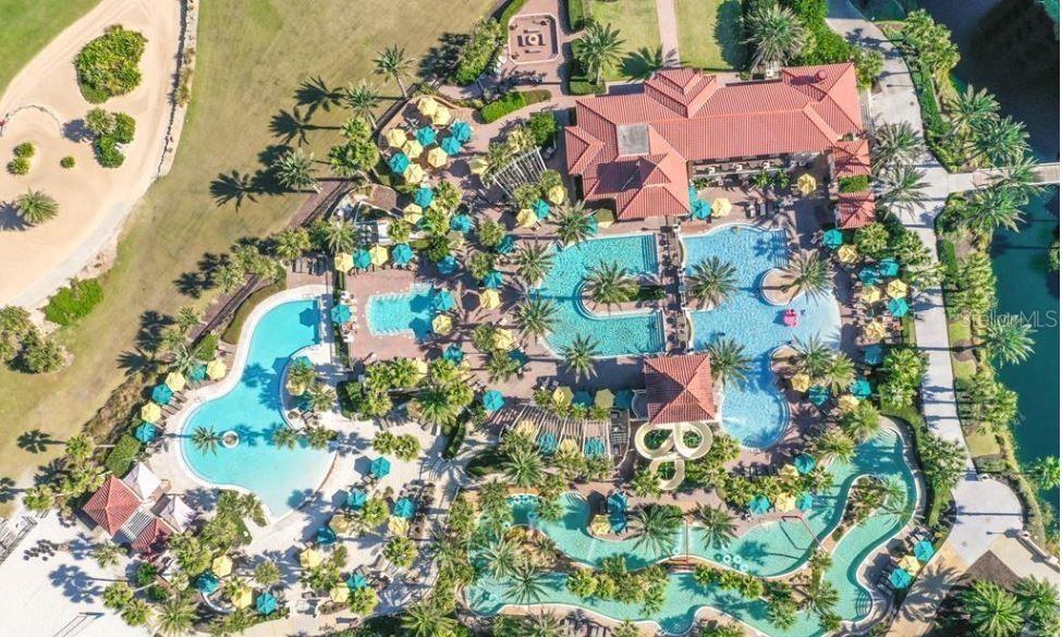 An aerial view shows a large resort-style swimming pool complex with multiple pools and slides — 200 OCEAN CREST DRIVE UNIT 231, PALM COAST, FL