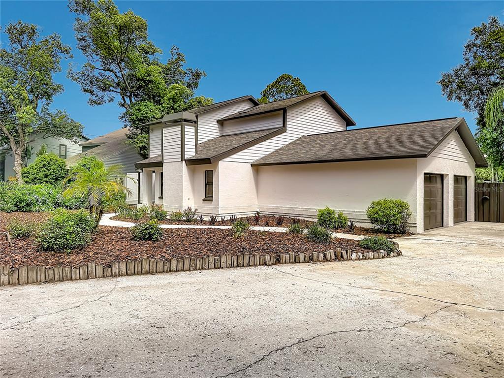 A two-story house with light-colored siding, a two-car garage, and a landscaped front yard — 87 1ST AVENUE NW, LUTZ, FL