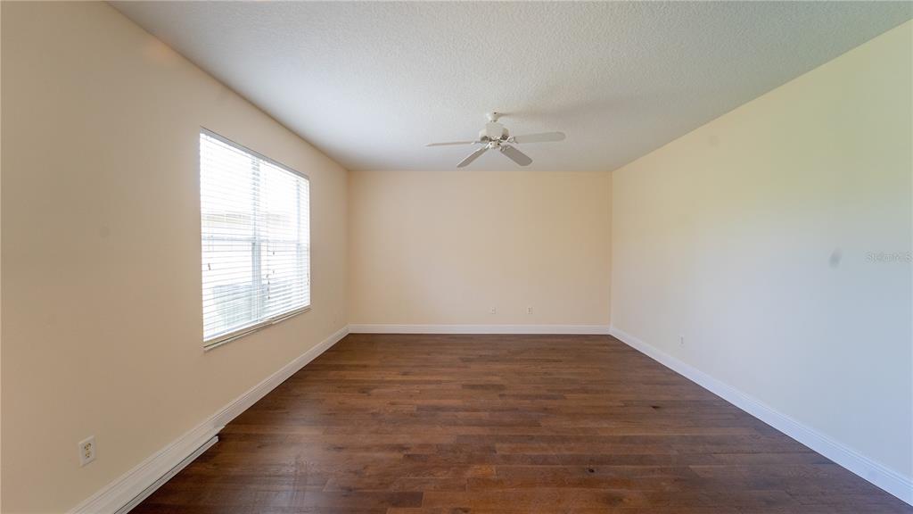An empty room with light-colored walls, a ceiling fan, and dark wood-look flooring — 2264 HILLSHIRE DRIVE, ORLANDO, FL