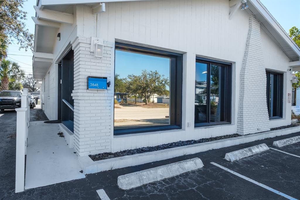 The exterior of a white brick commercial building features large windows and a parking lot — 3848 CENTRAL AVENUE, ST PETERSBURG, FL