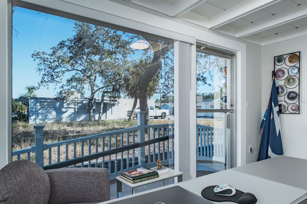 A sunroom with a desk, a gray armchair, and a view of a white pickup truck — 3848 CENTRAL AVENUE, ST PETERSBURG, FL