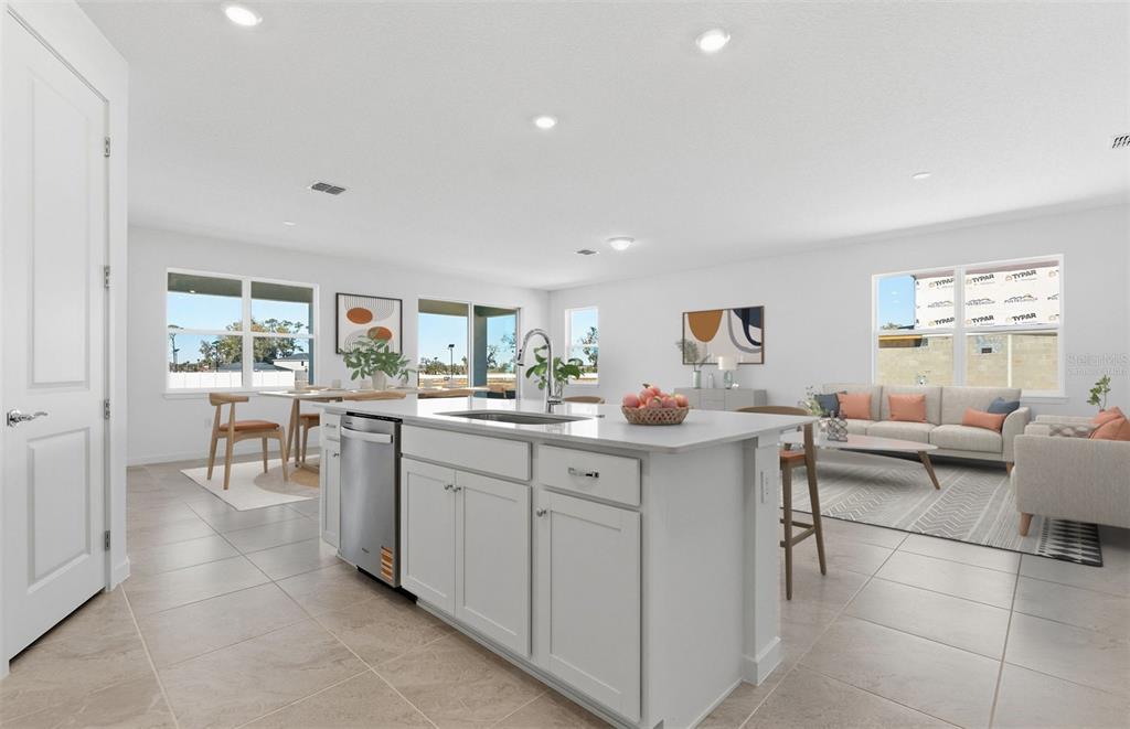 A bright, open-concept kitchen and living area features a central island with light gray cabinetry — 8132 SW 44TH COURT ROAD, OCALA, FL