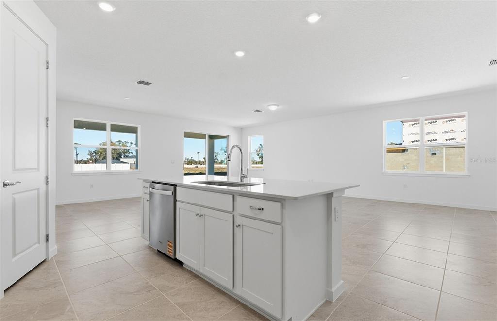 A kitchen island with a stainless steel dishwasher sits in a bright, open-concept living space — 8132 SW 44TH COURT ROAD, OCALA, FL
