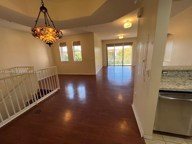 A living area with hardwood floors, a stained-glass chandelier, and a white staircase railing — 6360 NW 114th Ave # 233, Doral FL 33178, DORAL, FL