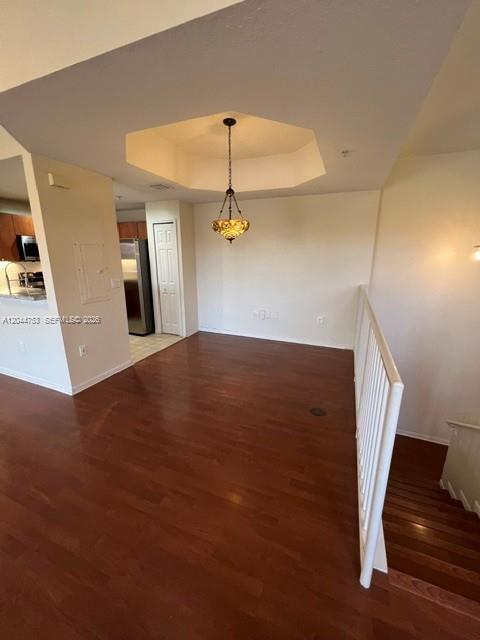 An interior view shows a dining area with hardwood floors, a tray ceiling, and chandelier — 6360 NW 114th Ave # 233, Doral FL 33178, DORAL, FL