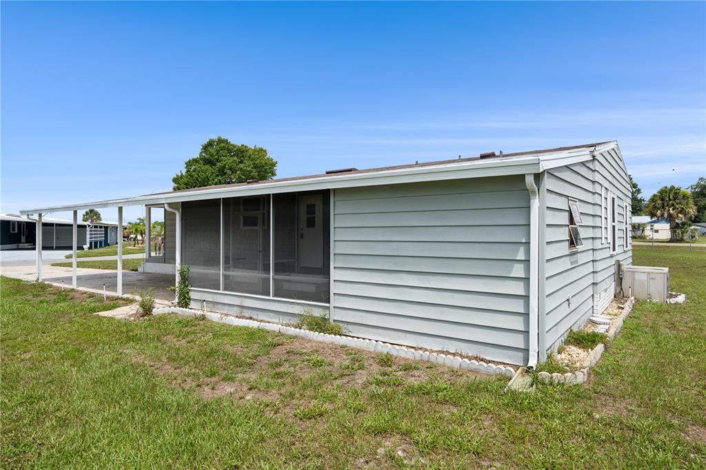 A light blue mobile home with a screened-in porch and an attached carport — 5035 LODGEWOOD DRIVE, LAKELAND, FL