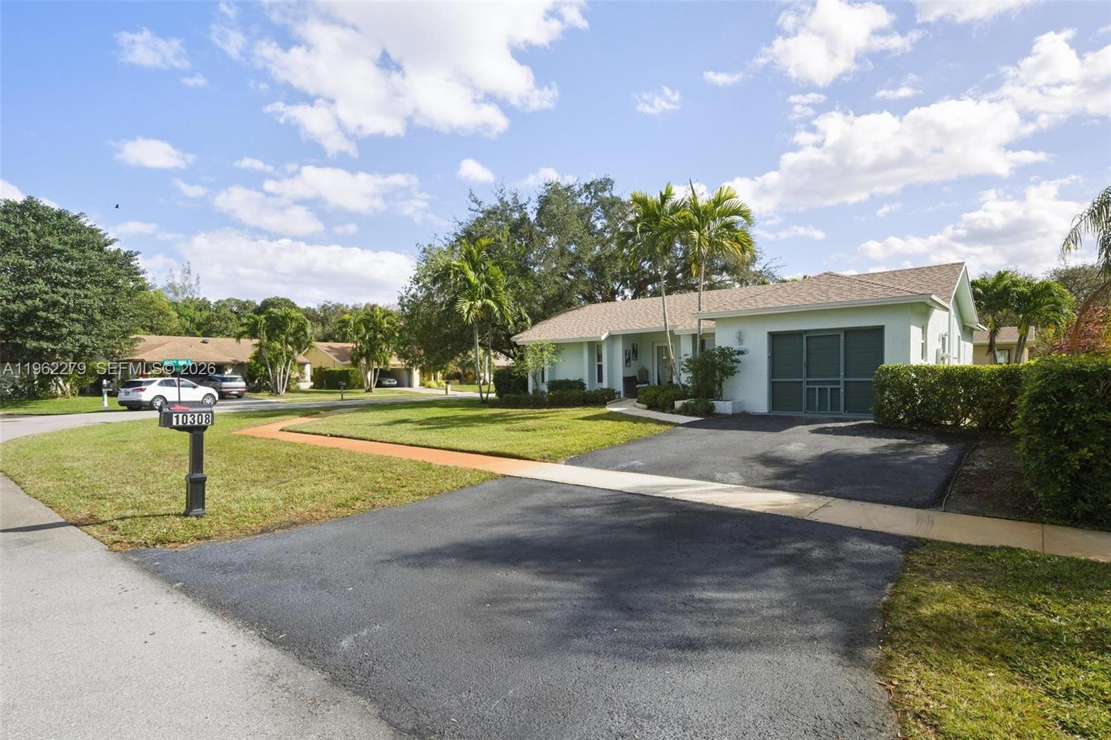 A single-story house with a paved driveway, a green garage door, and palm trees — 10308 Greenbriar Ct, Boca Raton FL 33498, BOCA RATON, FL