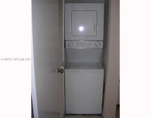 A white stacked washer and dryer unit sits inside a small laundry closet — 4055 W Mcnab Rd # H303, Pompano Beach FL 33069, POMPANO BEACH, FL