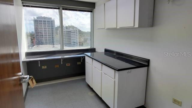 A small office space features white cabinets, a black countertop, and a large window view — 1510 F. D. ROOSEVELT AVE., GUAYNABO, PR