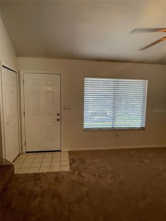 A room with beige carpet, a white door, and a window with horizontal blinds — 3504 NW 37TH AVENUE, GAINESVILLE, FL