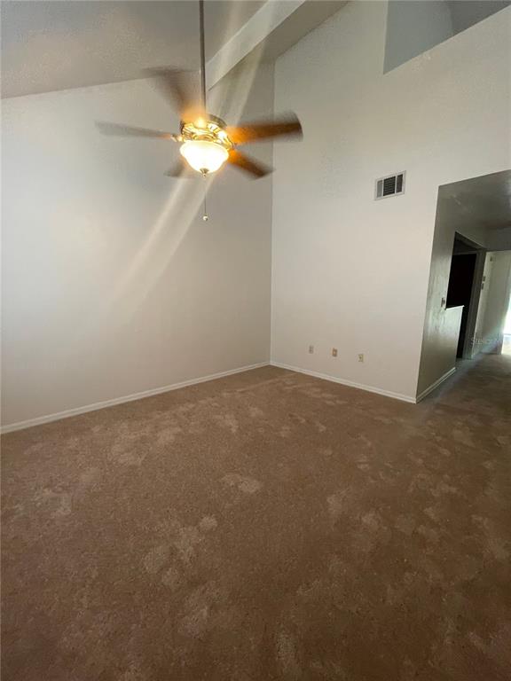 A room with beige carpet, white walls, a vaulted ceiling, and a ceiling fan — 3504 NW 37TH AVENUE, GAINESVILLE, FL