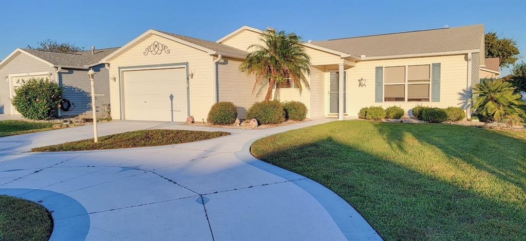 A single-story house with light-colored siding, a garage, and a paved driveway — 773 ARTESIA AVENUE, THE VILLAGES, FL