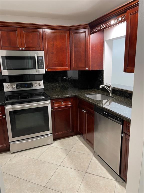 A kitchen features dark wood cabinets, stainless steel appliances, and dark granite countertops — 6549 Somerset Drive # 106, Boca Raton FL 33433, BOCA RATON, FL