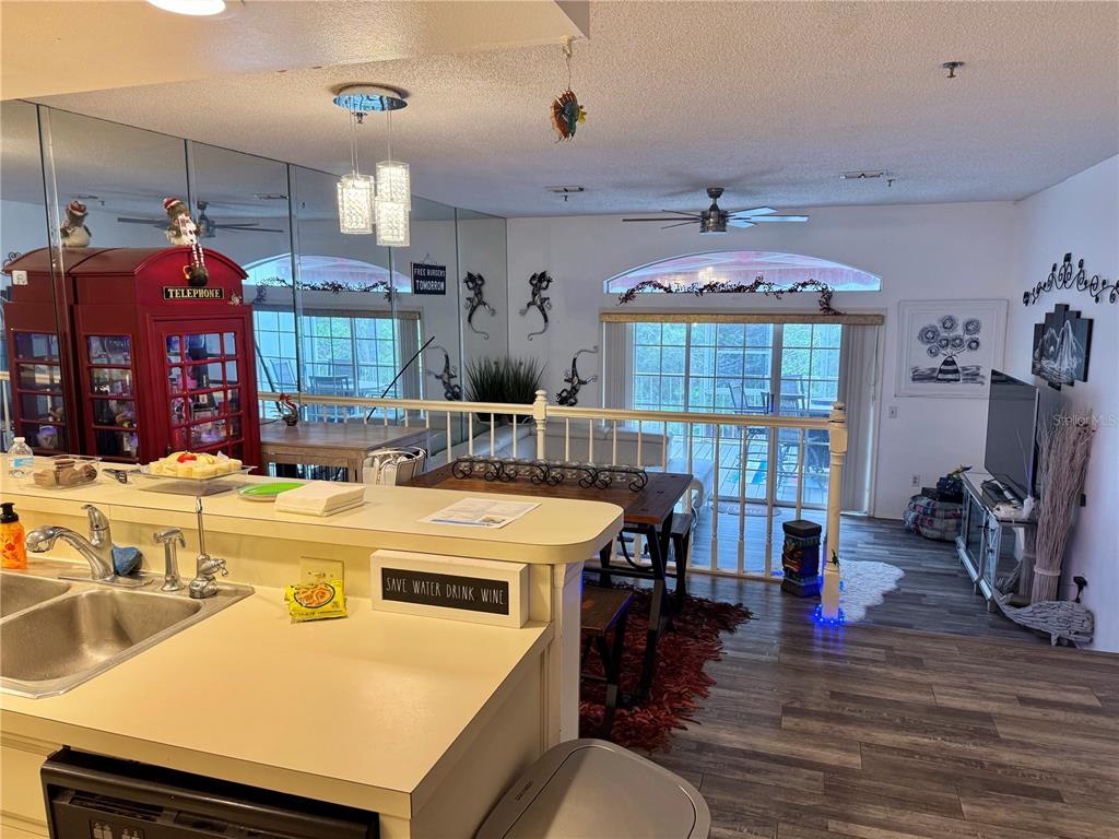 A kitchen overlooks a dining area and living room with a red telephone booth — 2111 VISTA DEL SOL CIRCLE UNIT 403, LUTZ, FL