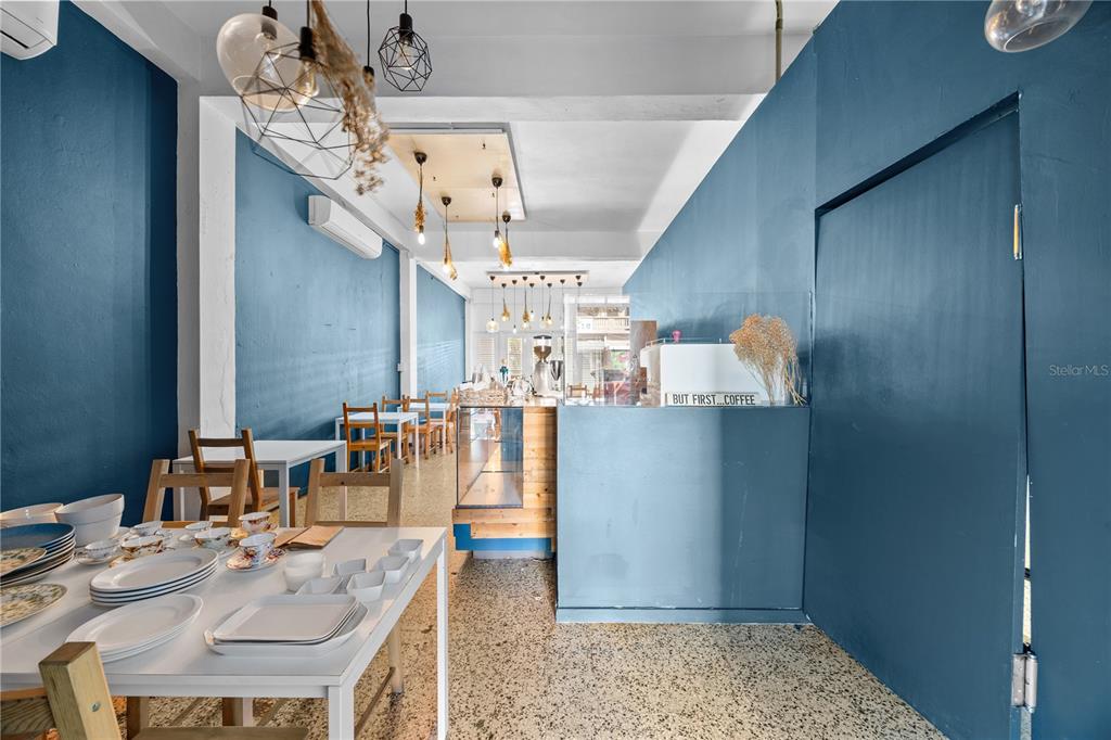 A small cafe interior features blue walls, white tables, and hanging pendant lights — 311 MENDEZ VIGO, DORADO, PR