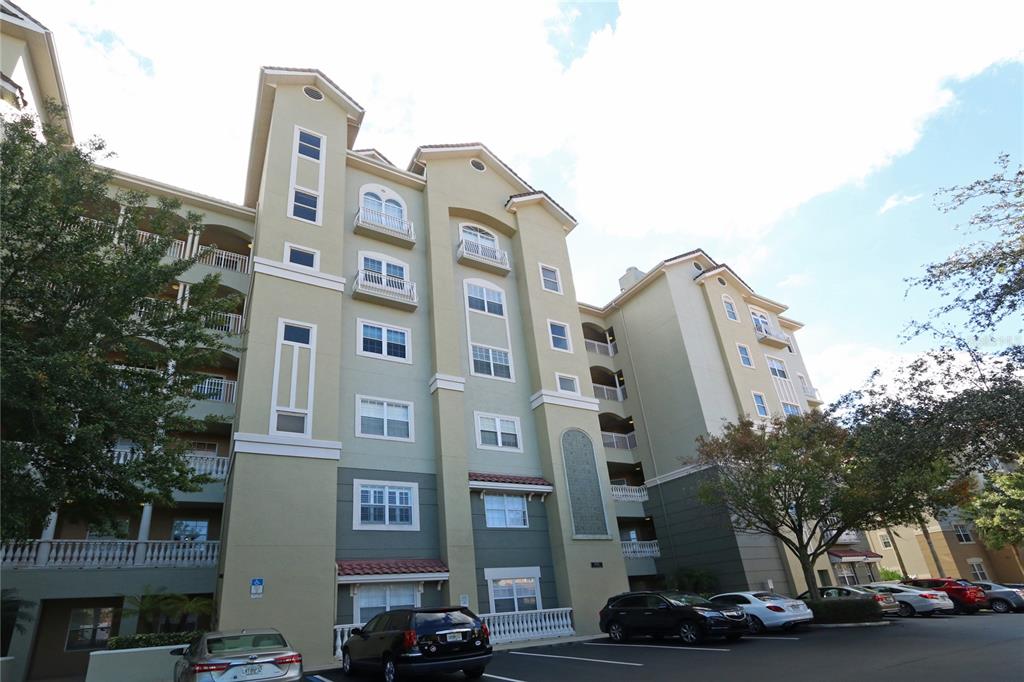 A multi-story apartment building with balconies and a parking lot in the foreground — 8761 THE ESPLANADE UNIT 22, ORLANDO, FL