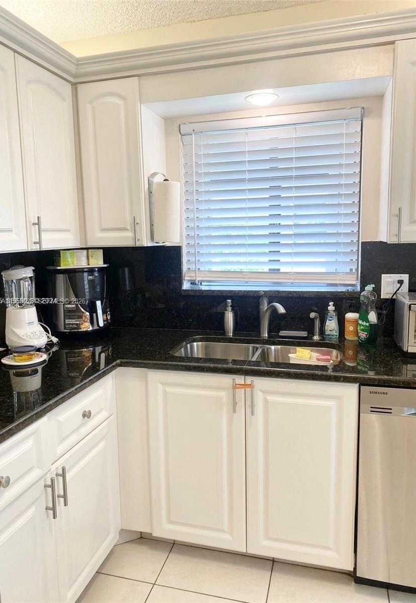 A kitchen features white cabinets, black countertops, a stainless steel sink, and a window — 8089 Sweetbriar Way, Boca Raton FL 33496, BOCA RATON, FL