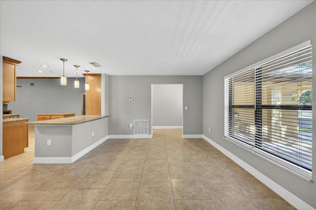 A kitchen with a breakfast bar and tile flooring opens into a dining area — 2883 MANDARIN PLACE, PALM HARBOR, FL