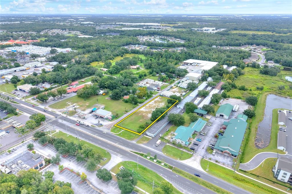 An aerial view shows a vacant rectangular lot outlined in yellow along a busy road — E RAYBURN ROAD, PLANT CITY, FL