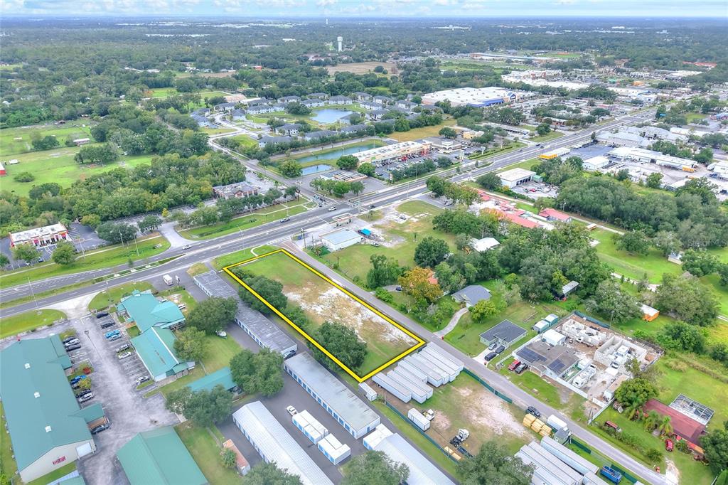 An aerial view shows a vacant rectangular lot outlined in yellow near a commercial road — E RAYBURN ROAD, PLANT CITY, FL