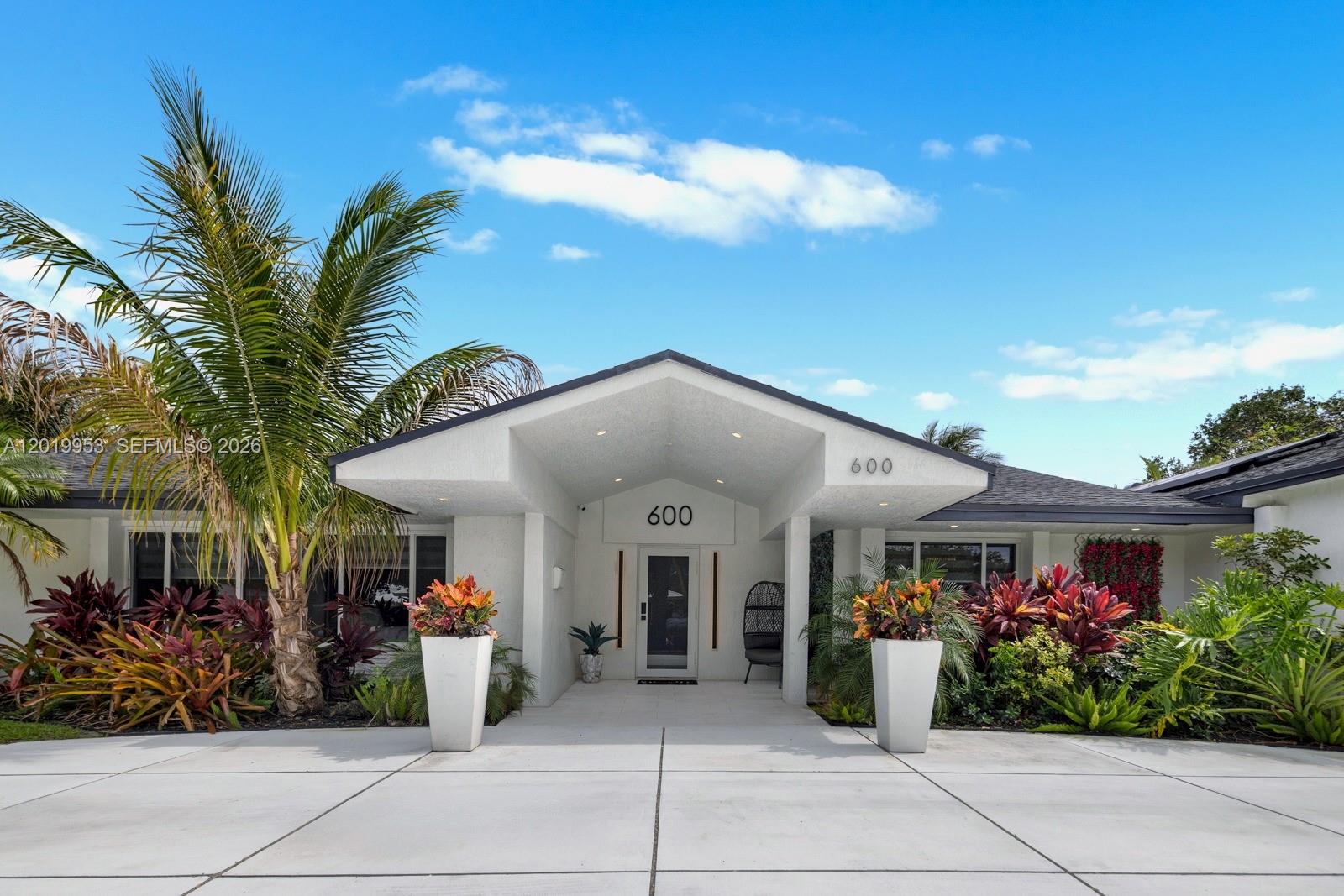 The exterior of a modern one-story house features a covered entryway with white pillars — 600 NE 4th St, Pompano Beach FL 33060, POMPANO BEACH, FL