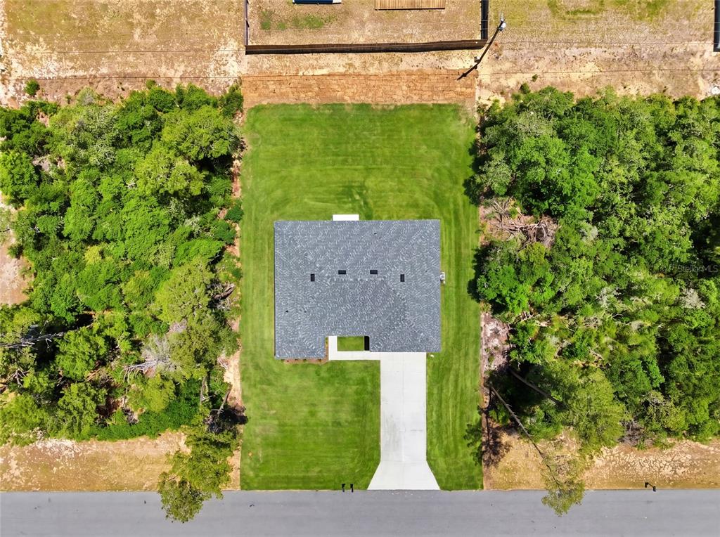 An aerial view shows a house with a gray roof, concrete driveway, and surrounding trees — 2780 SW 162ND LANE, OCALA, FL