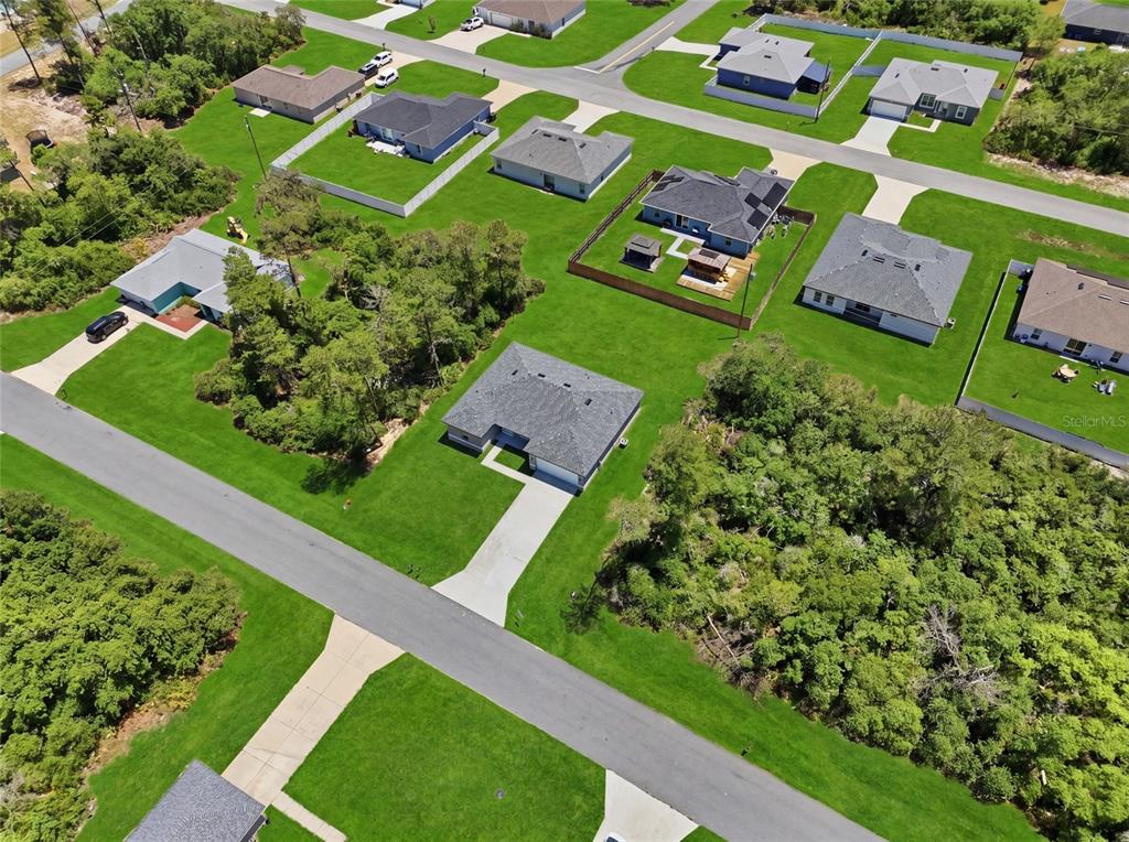 An aerial view shows several single-family homes surrounded by green lawns and wooded areas — 2780 SW 162ND LANE, OCALA, FL